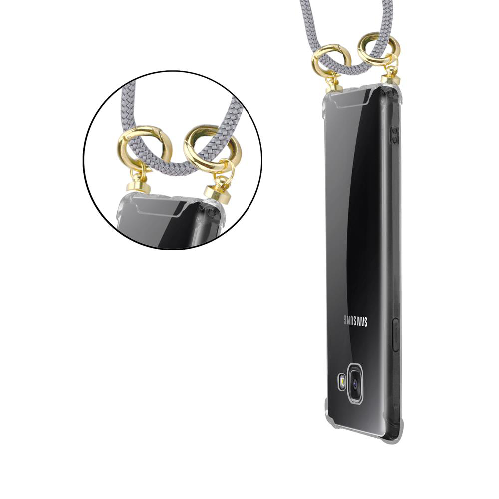 Funda de teléfono transparente con cordón gris y herrajes dorados. Vista cercana.
