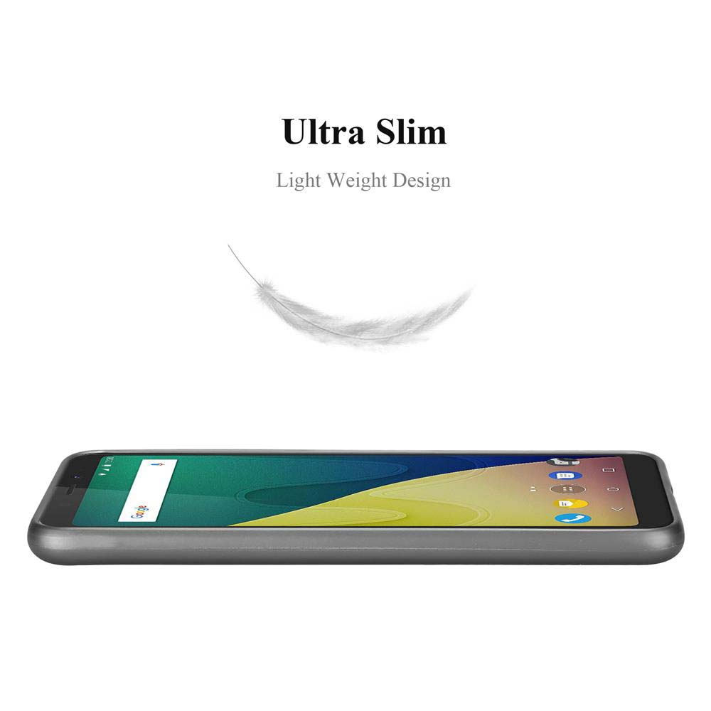 Ein schlankes graues Smartphone liegt auf einer weißen Fläche. Eine Feder schwebt darüber.