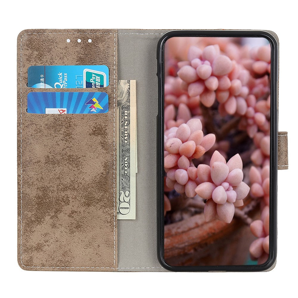 Una custodia a portafoglio marrone per telefono contiene carte e contanti. Lo schermo mostra succulente rosa.