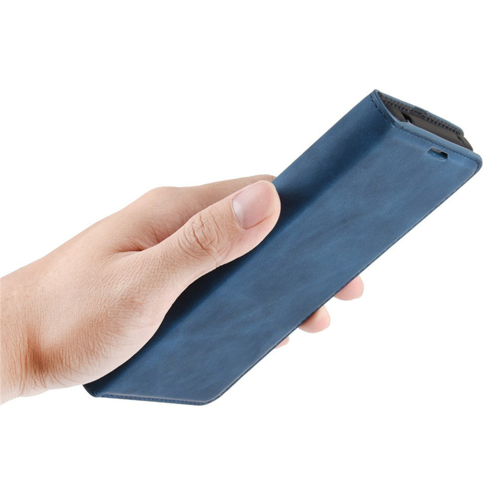 Una mano che tiene una custodia blu scuro per telefono.