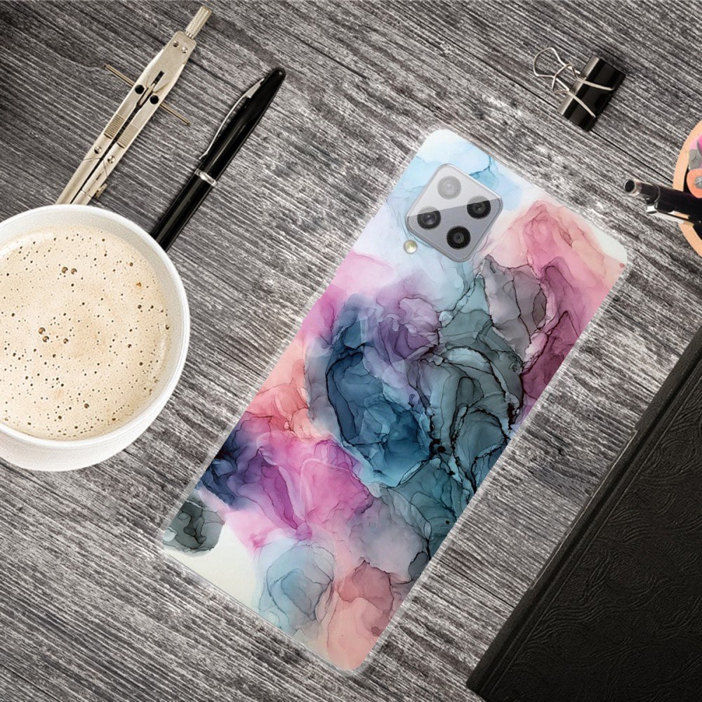 Un telefono con un motivo astratto rosa, blu e grigio su una scrivania di legno.