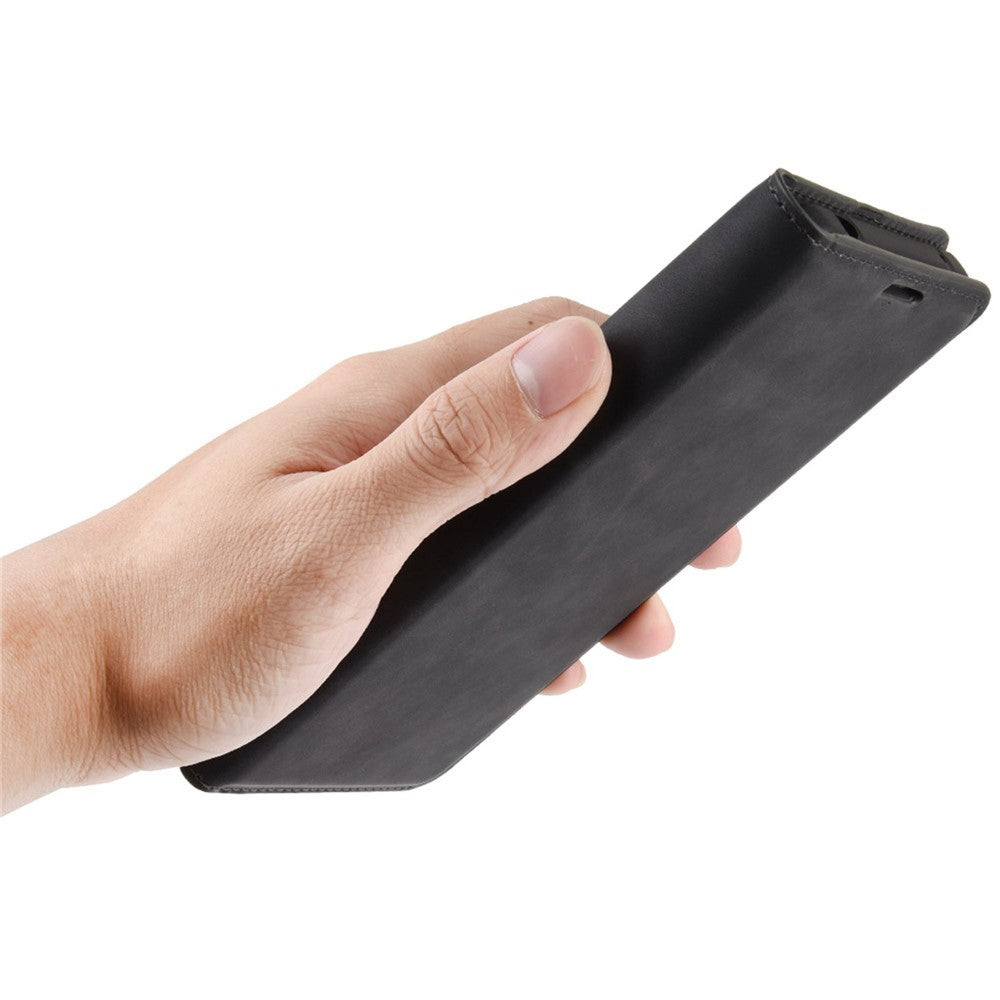 Una mano tiene una custodia per telefono nera con la copertina aperta.