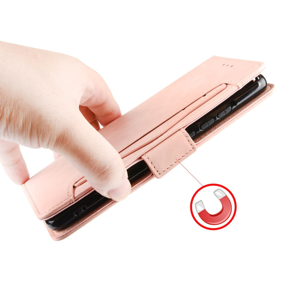 Una mano tiene una custodia rosa per telefono con un telefono nero all'interno. Icona magnete vicina.