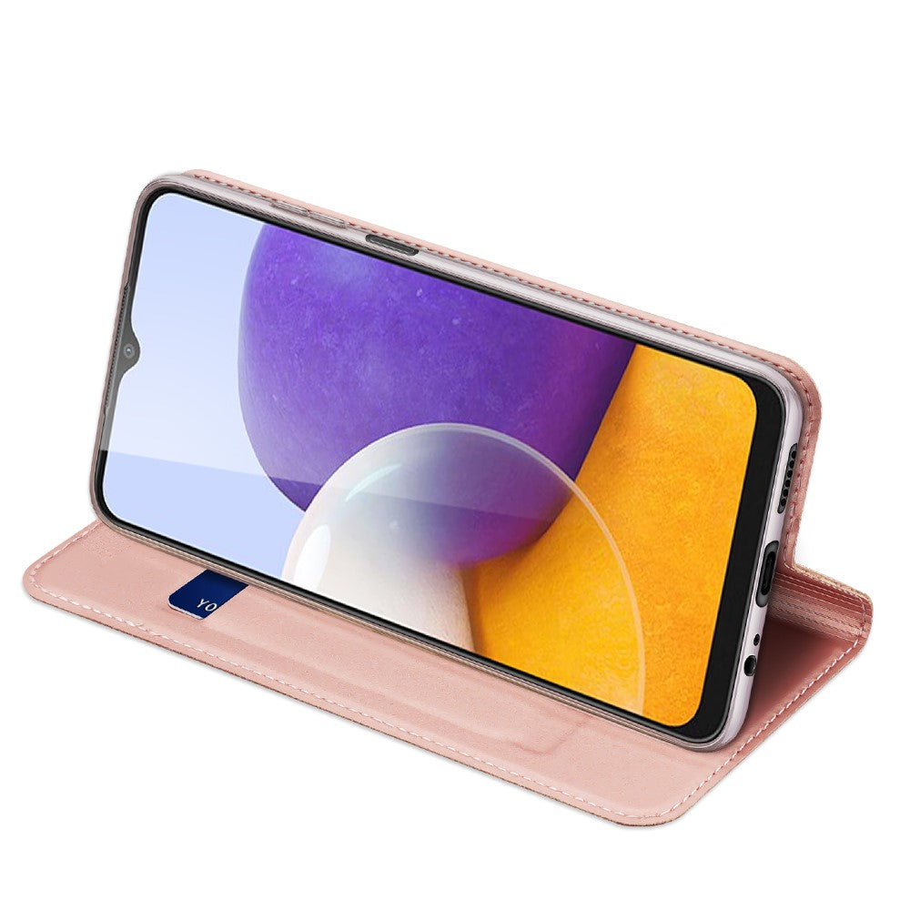 Una custodia rosa per telefono con copertina apribile, che mostra uno smartphone con sfondo viola e arancione.