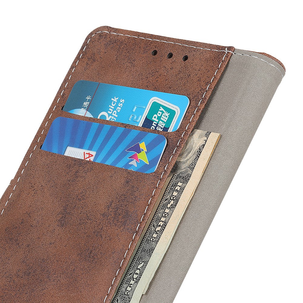 Un portafoglio marrone con due carte e del contante che spunta dal lato.