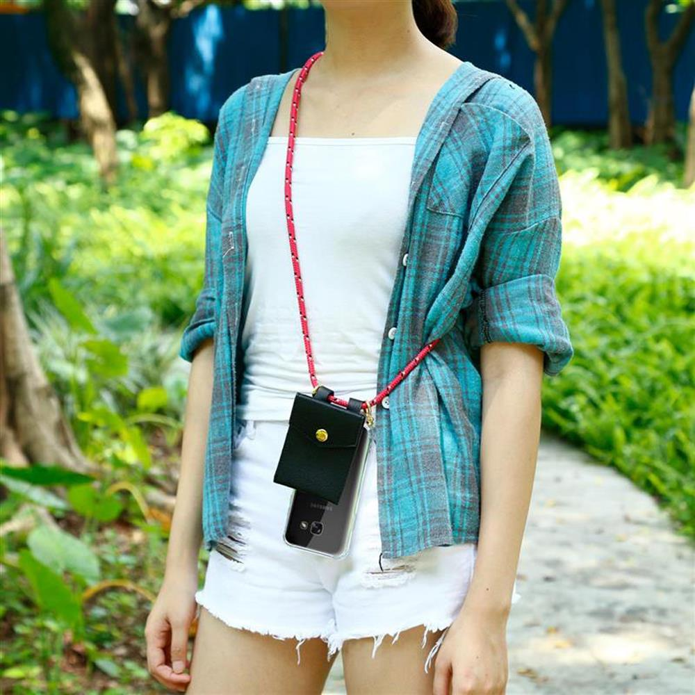 Una donna con camicia a quadri blu-grigio e pantaloncini bianchi indossa una borsa per telefono con cordino.
