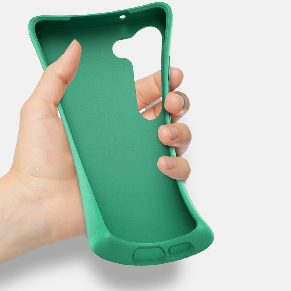 Eine Hand hält eine grüne Handyhülle mit Ausschnitten für Kamera und Anschlüsse.
