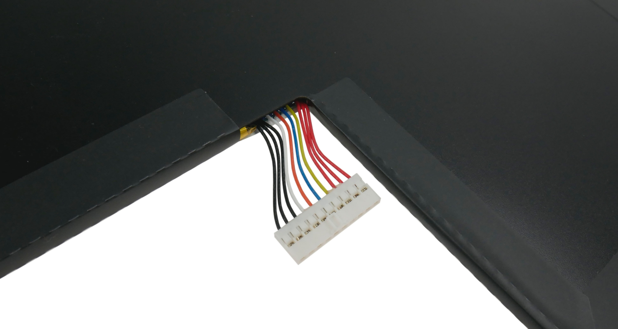 Białe złącze z kolorowymi przewodami wychodzącymi z czarnego urządzenia.