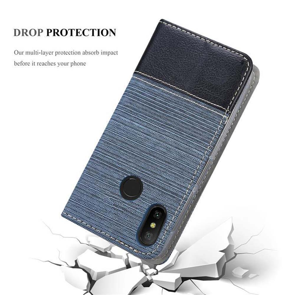 Blaues Handycover mit schwarzem Lederakzent, das auf zerbrochenem Boden liegt.