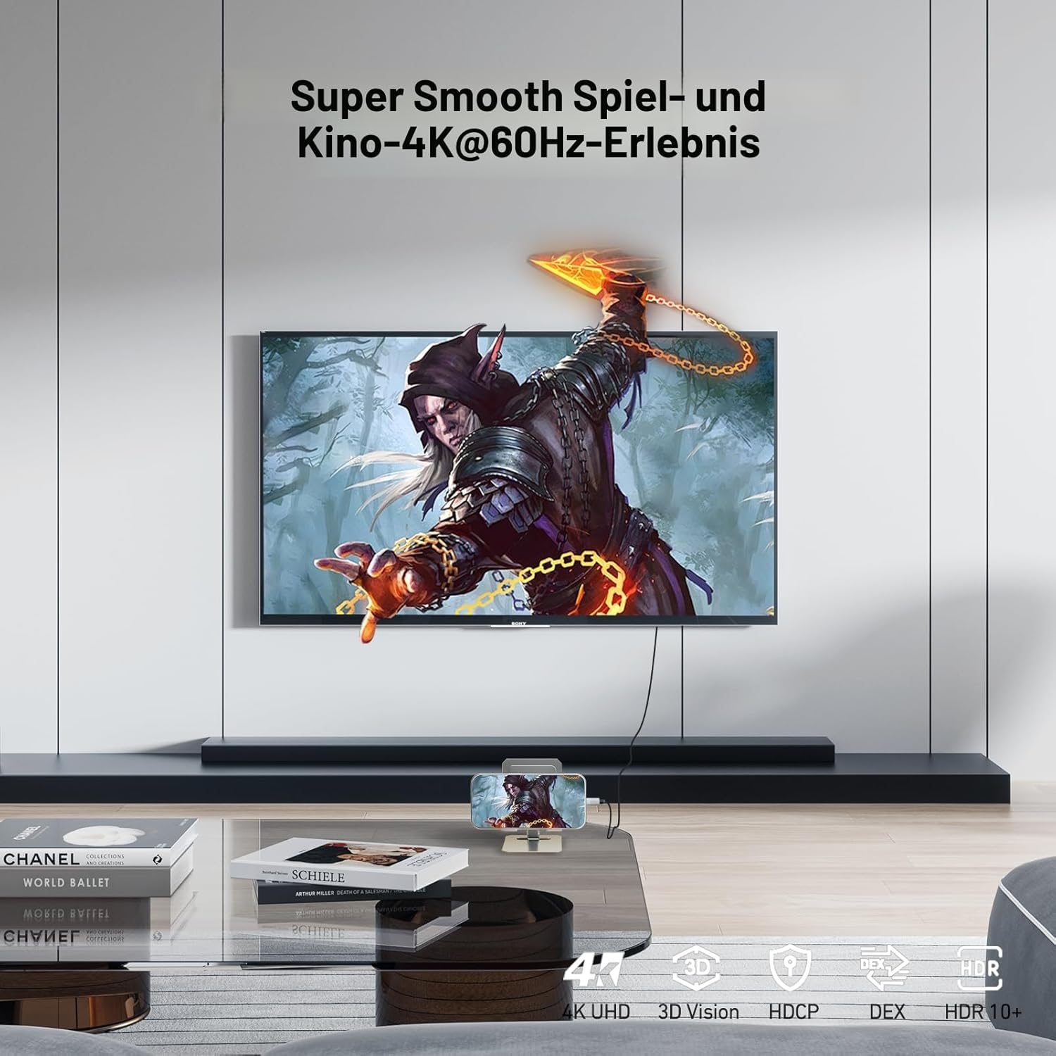 Ein Fantasy-Charakter mit Kapuze auf einem 4K-Fernseher. Auf dem Couchtisch liegen Bücher.