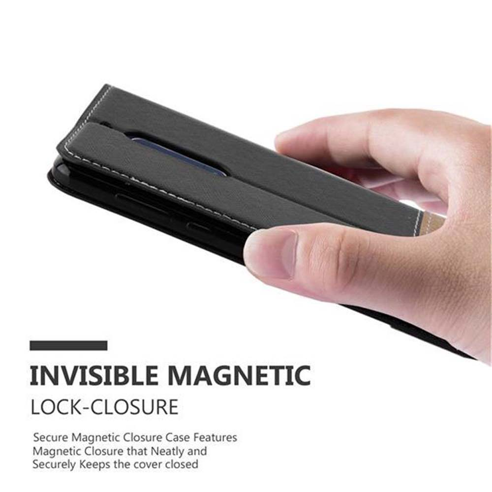 Mano che tiene una custodia per telefono nera con chiusura magnetica.
