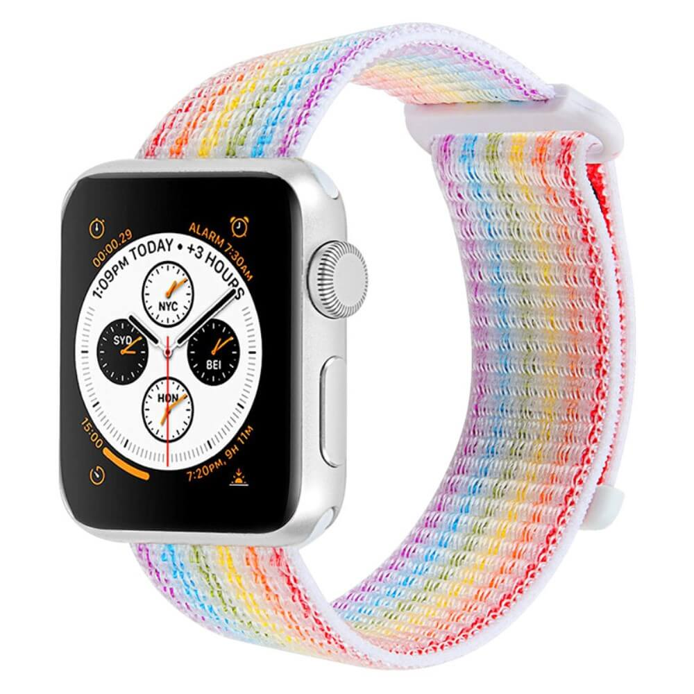 Une montre connectée argentée avec bracelet à rayures arc-en-ciel affiche plusieurs horloges.