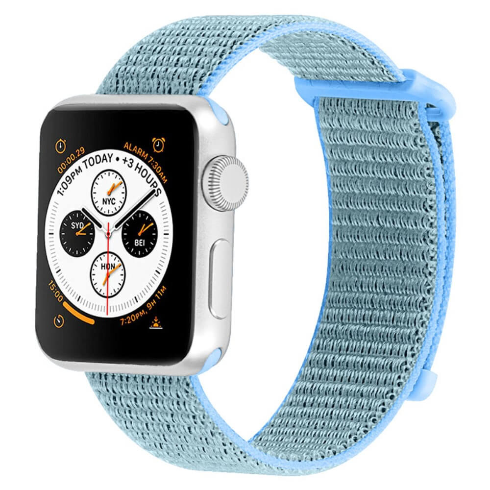Montre connectée argentée avec bracelet tissé bleu clair, affichant plusieurs fuseaux horaires.