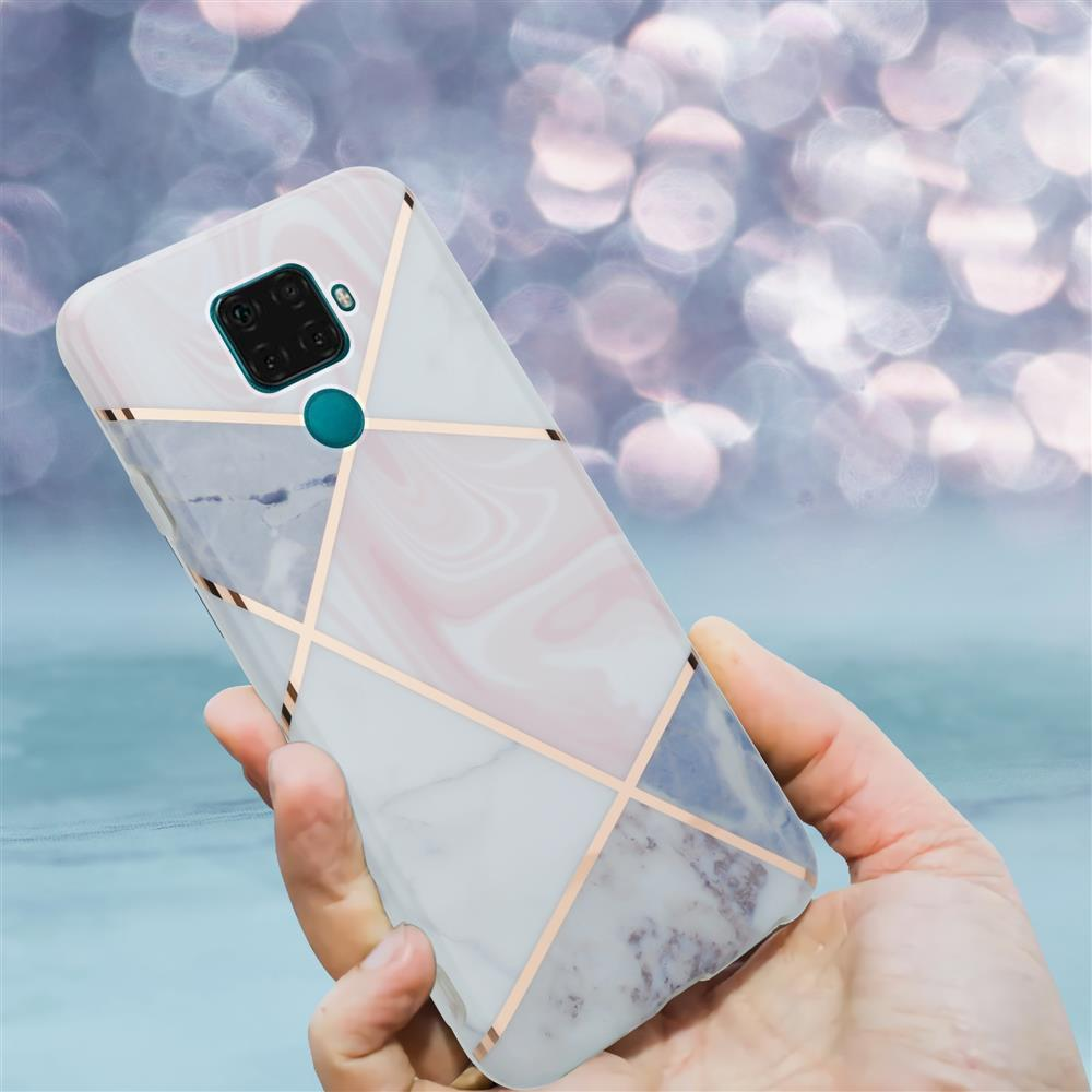 Una mano tiene uno smartphone con motivo a marmo e linee oro rosa.