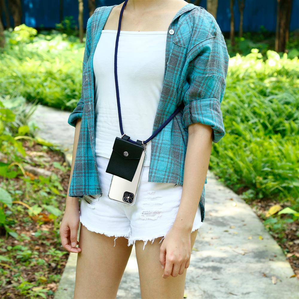 Donna con custodia per telefono su cordino, indossa camicia a quadri e shorts bianchi.