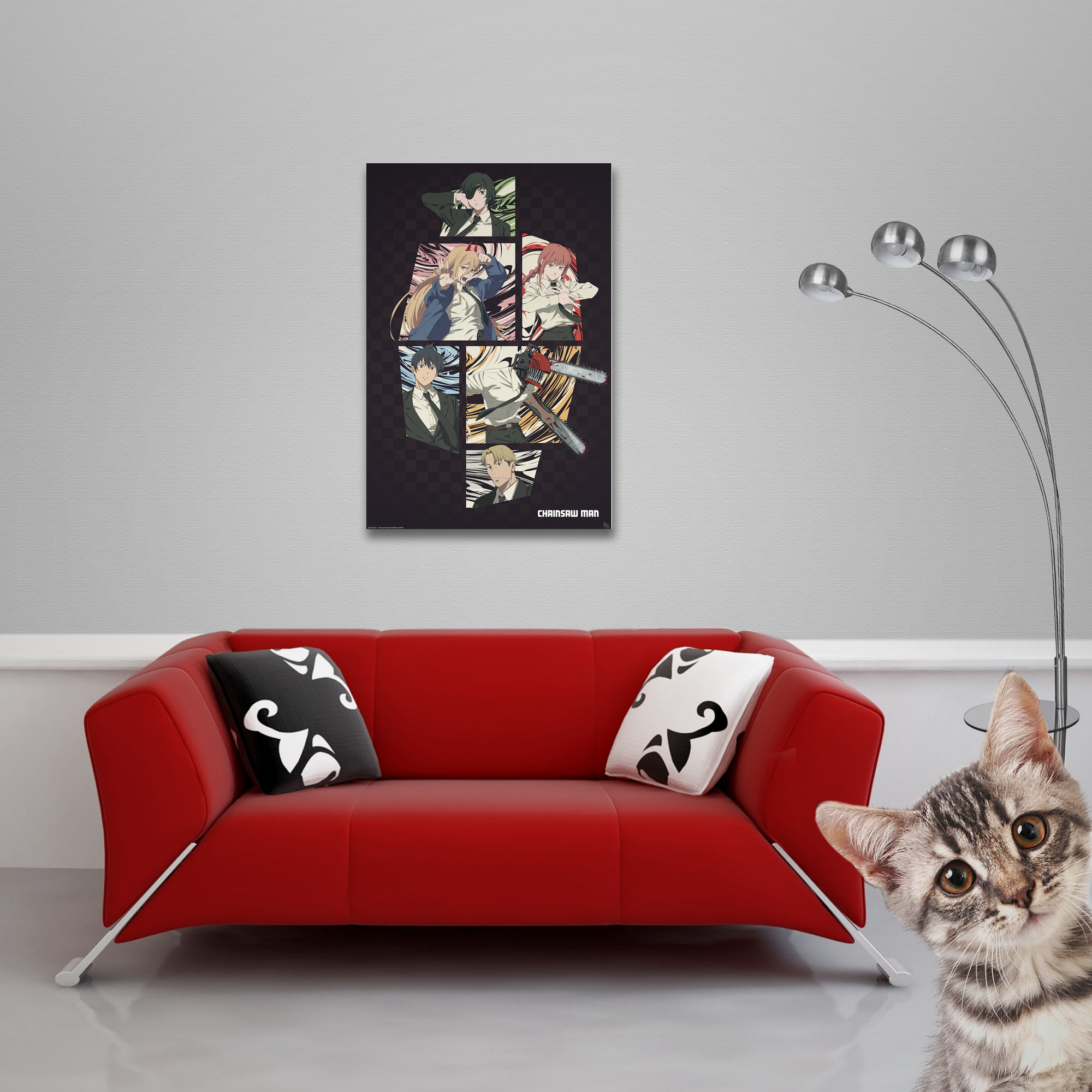 Ein rotes Sofa mit Kissen, einem Poster und einer Katze.