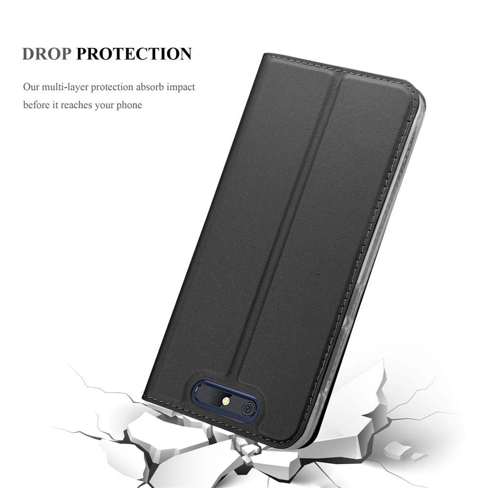 Funda de teléfono negra cerrada cayendo sobre suelo agrietado.