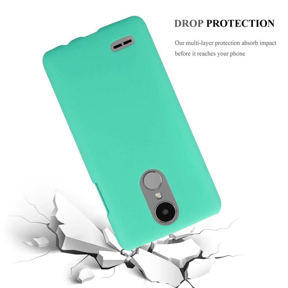 Una custodia per telefono verde acqua cade su terreno screpolato.