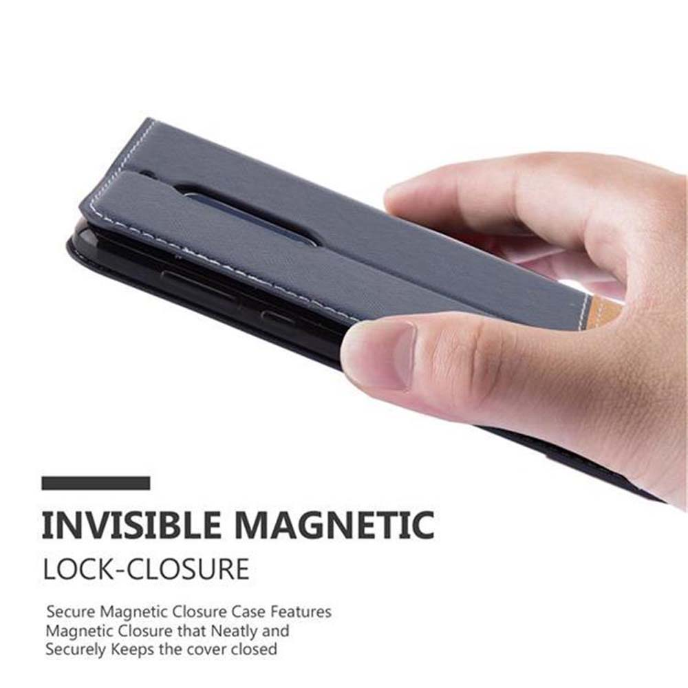 Mano che tiene una custodia per telefono grigia con chiusura magnetica.
