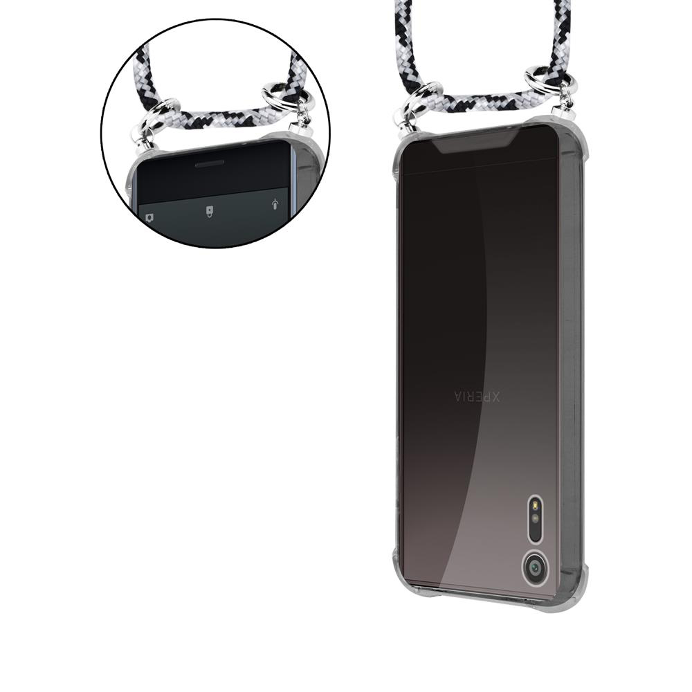 Uno smartphone in custodia trasparente con laccetto bianco e nero.