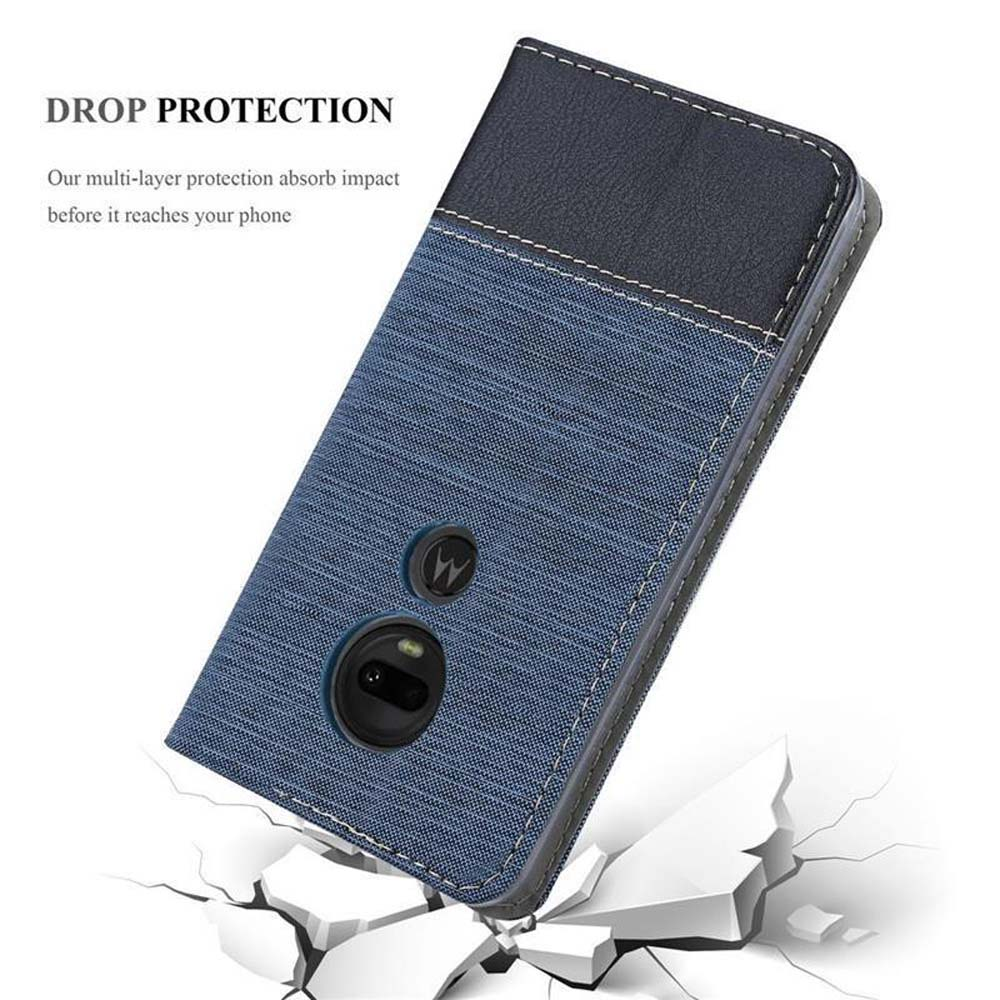 Custodia blu per telefono con sezione in pelle nera che cade su terreno screpolato.