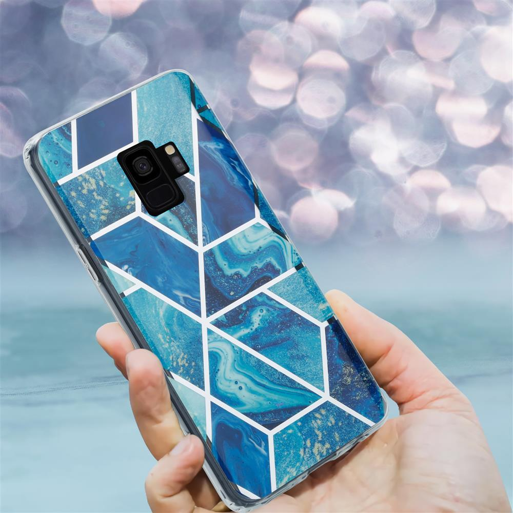 Mano che tiene uno smartphone con cover effetto marmo blu.
