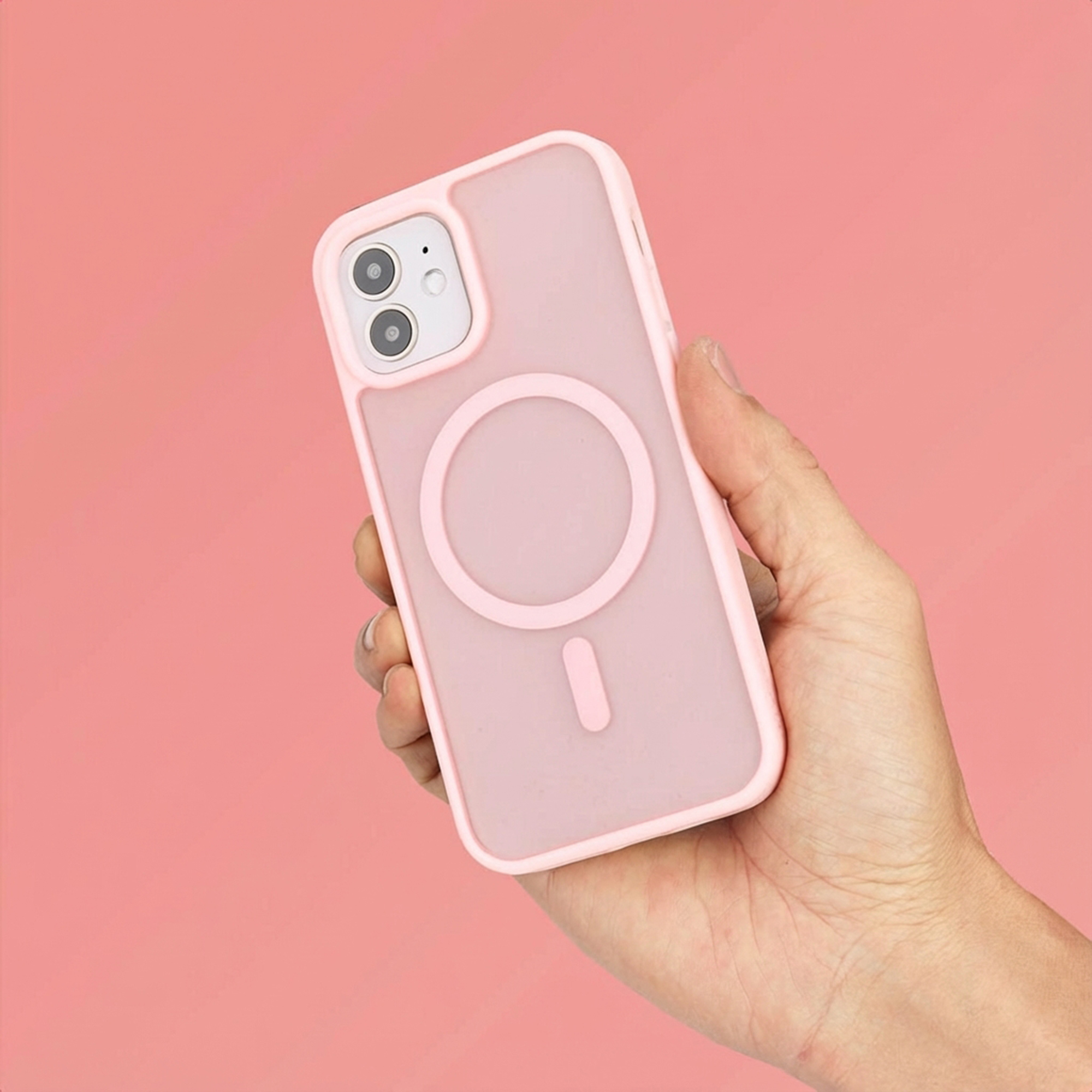 Een hand houdt een roze telefoonhoesje met cameralens en cirkelvormig ontwerp vast.