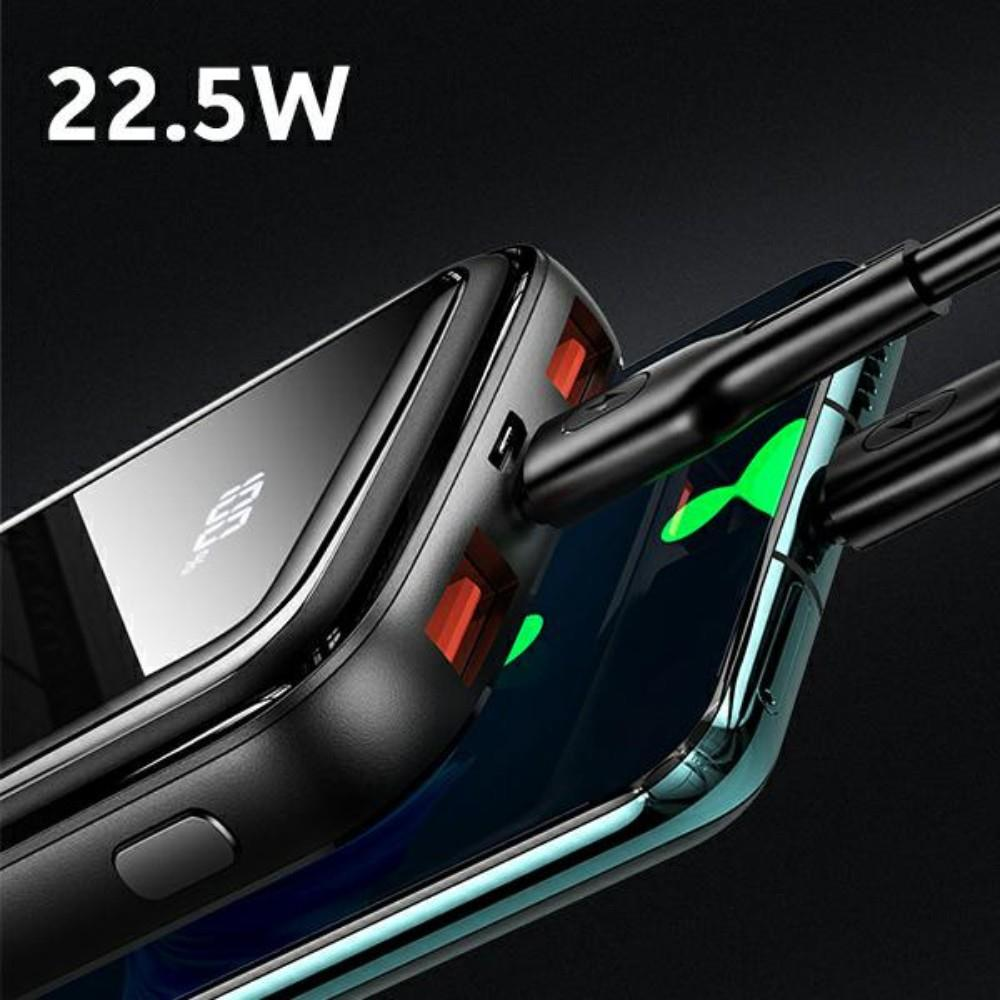 Un power bank nero da 22,5W carica uno smartphone. Schermo verde.
