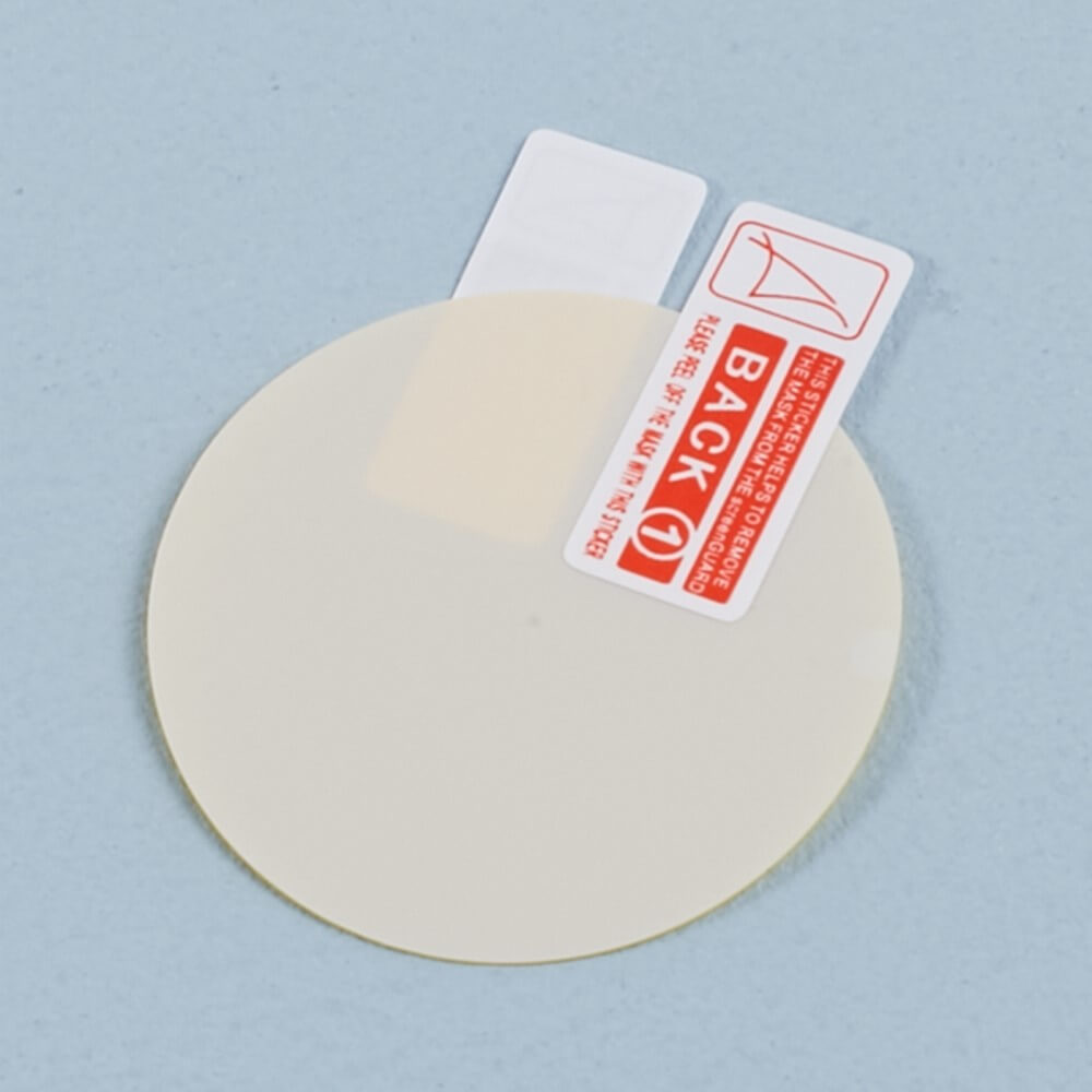 Un protecteur d'écran rond, couleur crème, avec un autocollant "BACK 1".