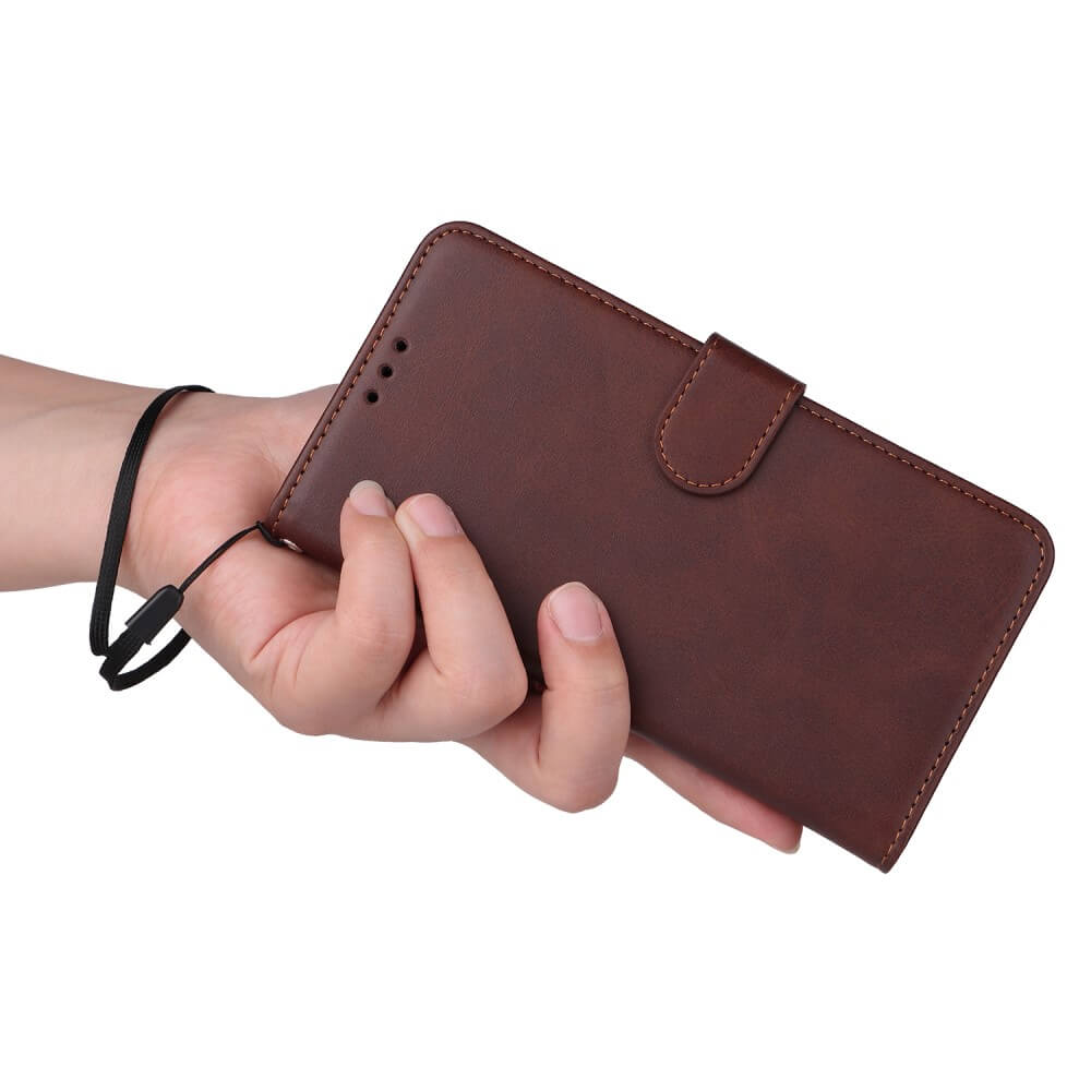 Eine braune Handyhülle mit Riemen wird von einer Hand gehalten.