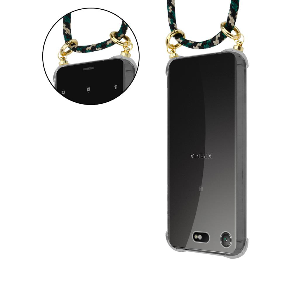 Ein Smartphone mit Trageband in Schwarz, Grün und Gold, das an einem transparenten Gehäuse befestigt ist.