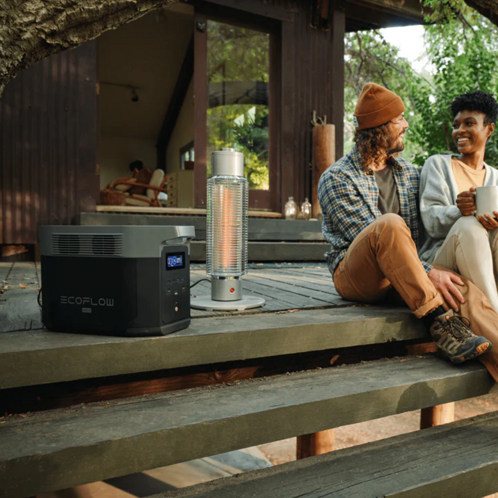 Bir çift, ısıtıcı ve güç istasyonu ile bir kulübenin dışındaki ahşap verandada oturuyor.
