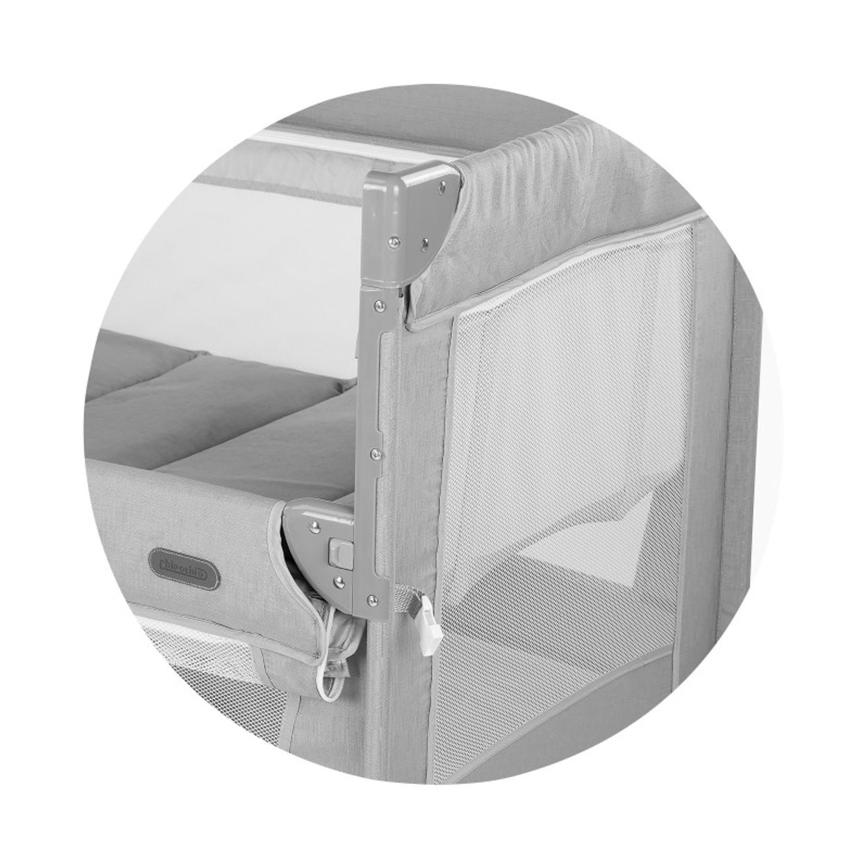 Graues Babybett mit Netzseiten und gepolsterter Matratze.