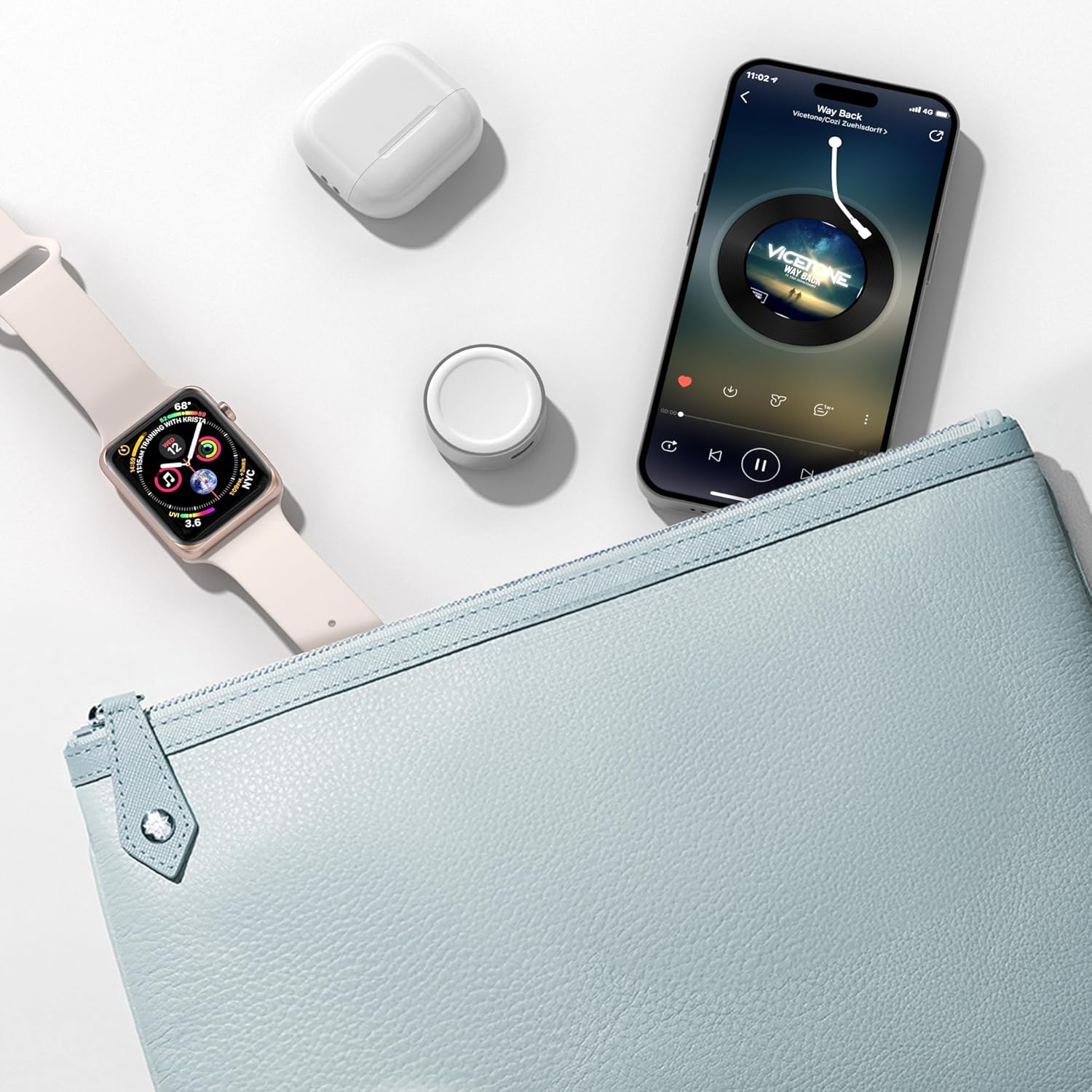 Ein Smartphone mit Musikwiedergabe, eine Smartwatch, Ohrhörer und eine hellblaue Tasche.