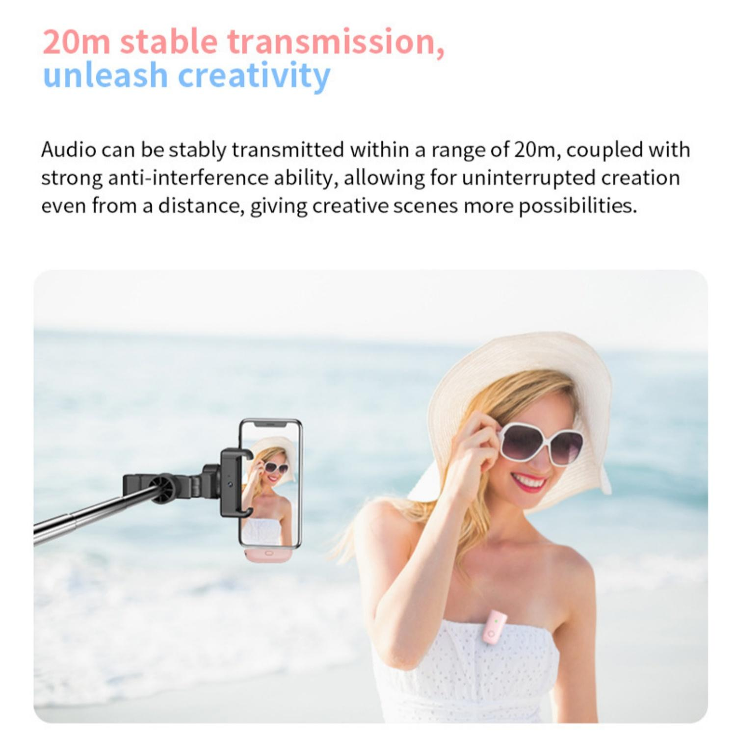 Eine Frau am Strand macht ein Selfie mit einem Selfie-Stick. Ein Mikrofon ist an ihrer Kleidung befestigt.