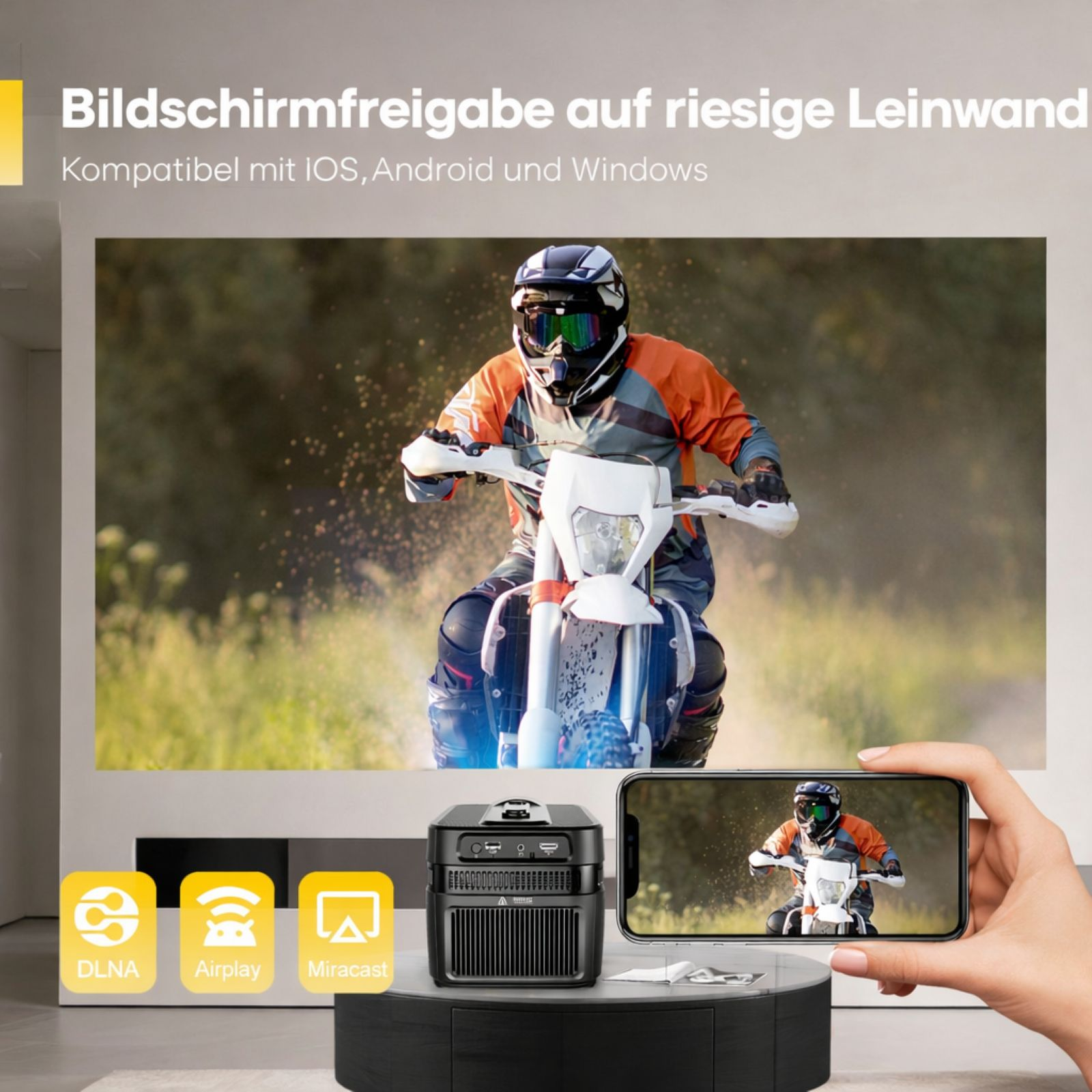Ein Motorradfahrer auf einer Leinwand, ein Projektor und ein Handy.