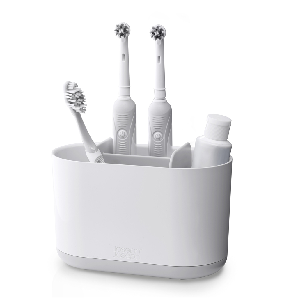 Un soporte blanco con dos cepillos eléctricos, un cepillo manual y un tubo.