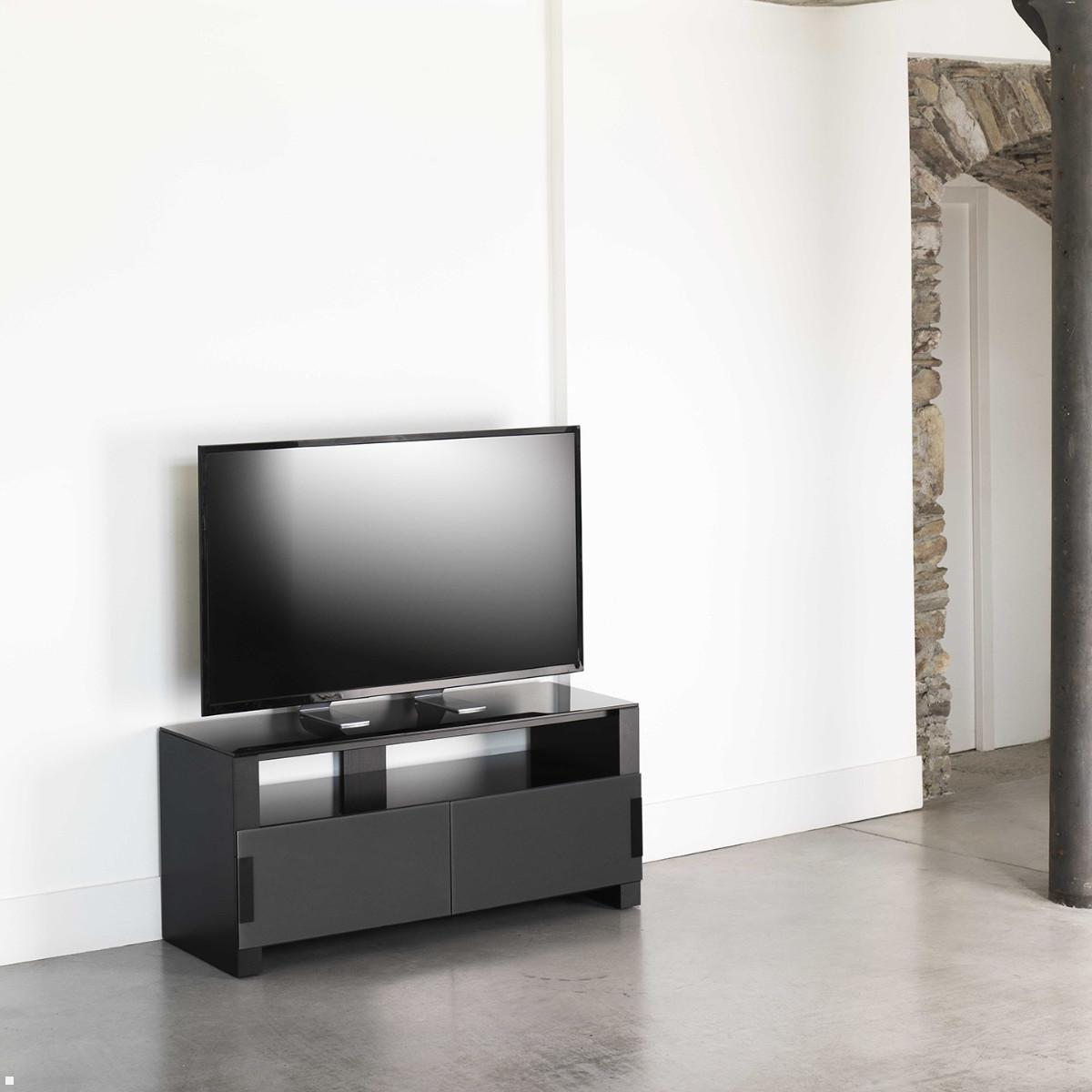Ein schwarzer Fernsehständer mit einem großen Fernseher steht an einer weißen Wand.