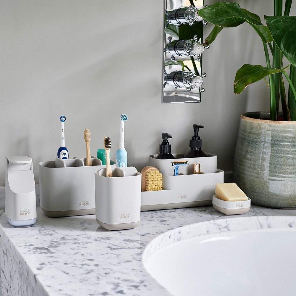 Organizador de baño con dispensador de jabón, cepillos y jabón.
