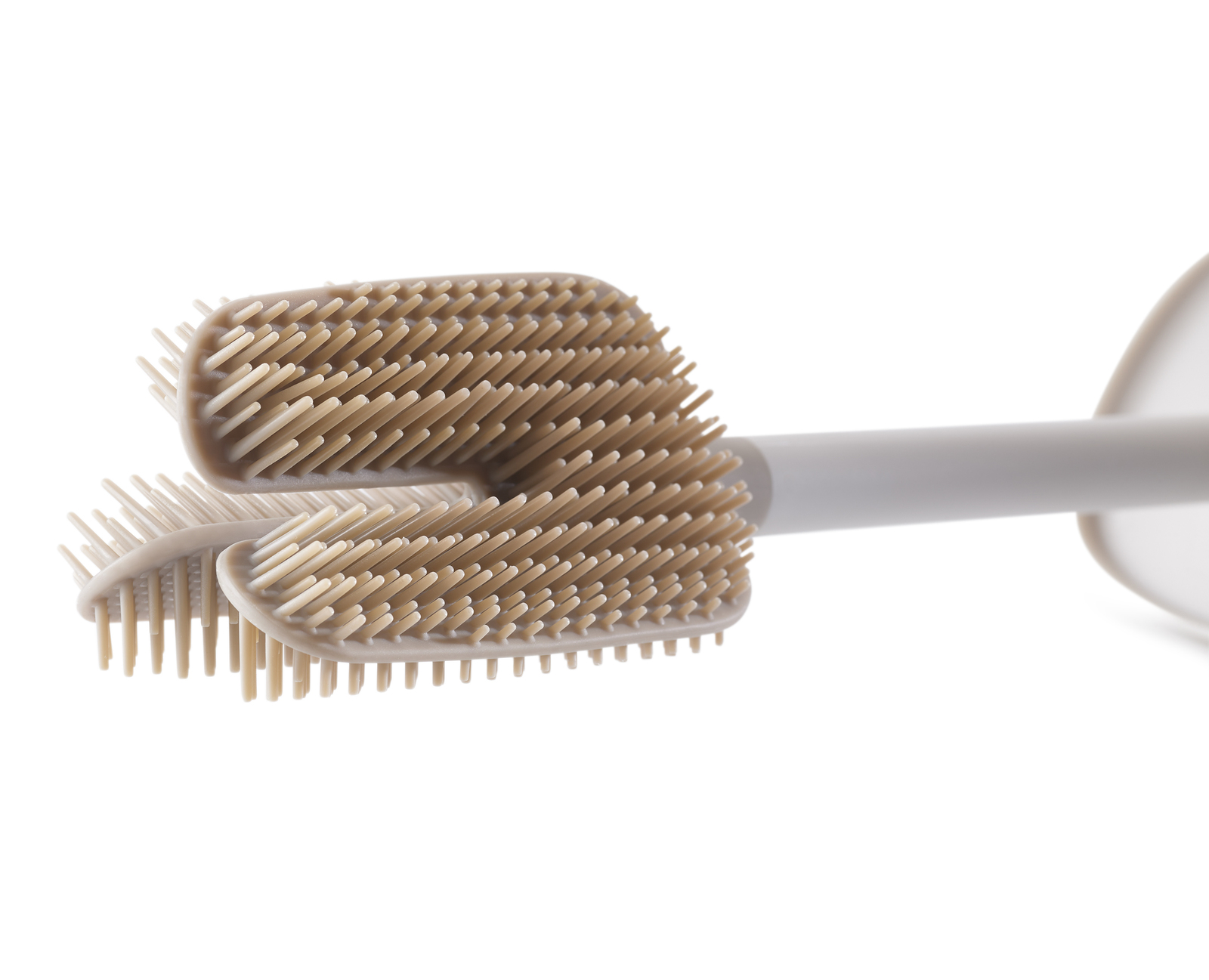 Una cabeza de cepillo de inodoro de silicona beige con cerdas largas.