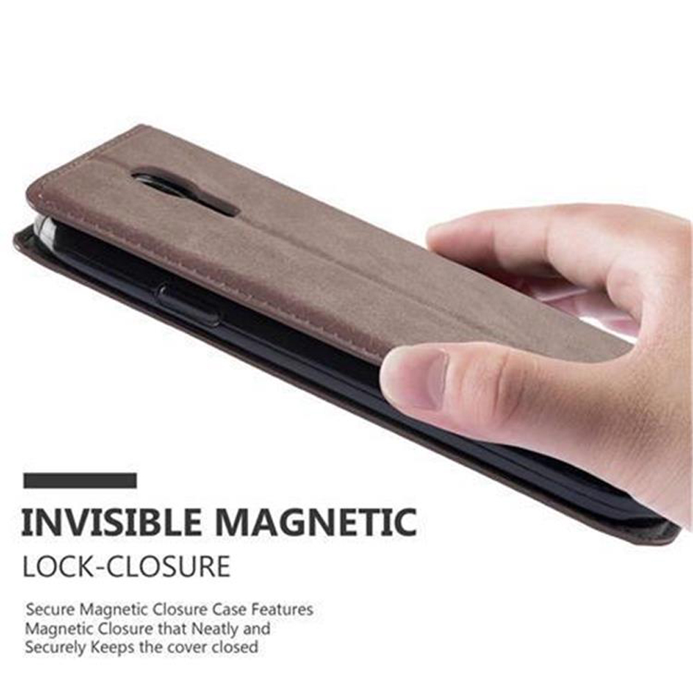 Una funda de teléfono marrón con cierre magnético la sostiene una mano.