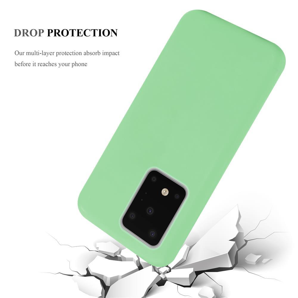 Una cover verde chiaro per telefono con foro per fotocamera cade su terreno bianco incrinato.