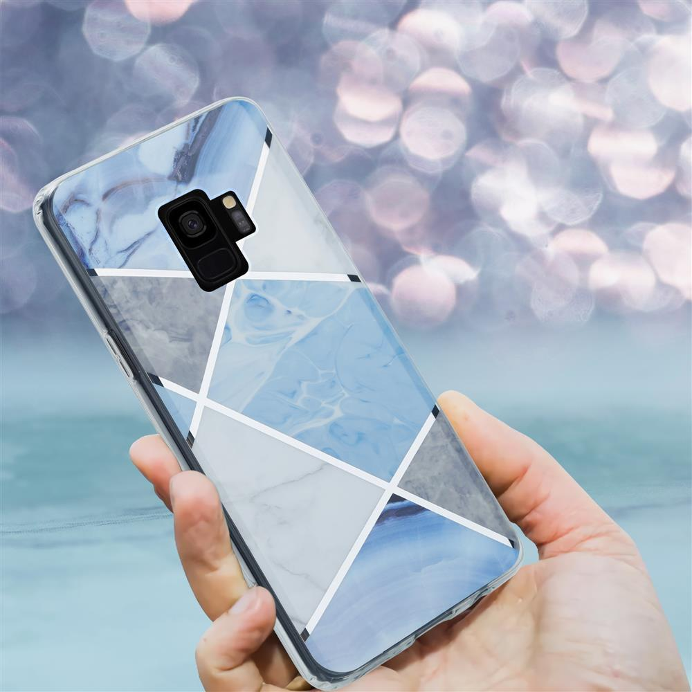 Una mano tiene uno smartphone con cover geometrica in marmo blu. Sfondo bokeh sfocato.