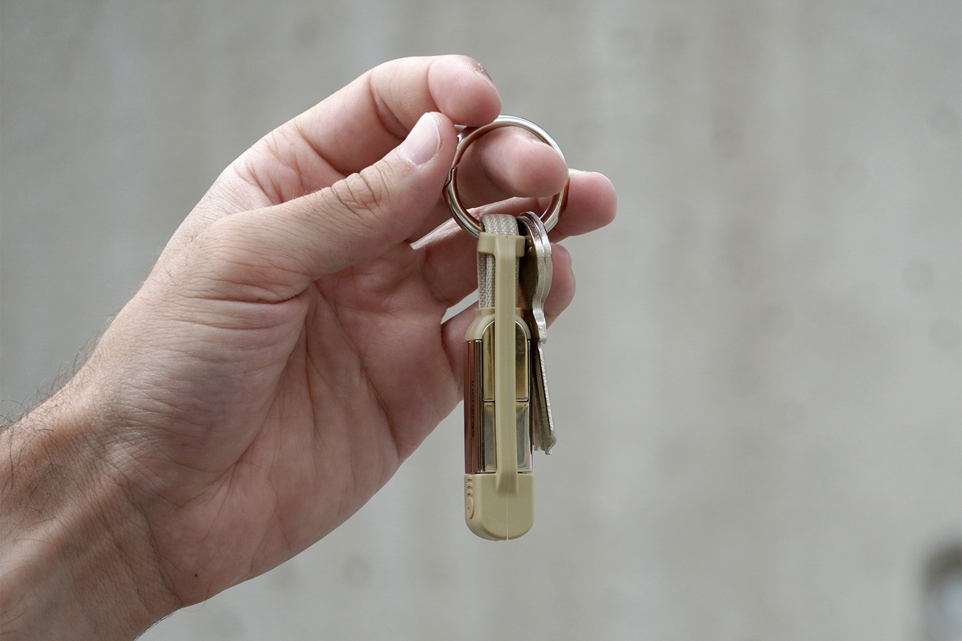 Een hand die een sleutelbos vasthoudt met een sleutelhanger.