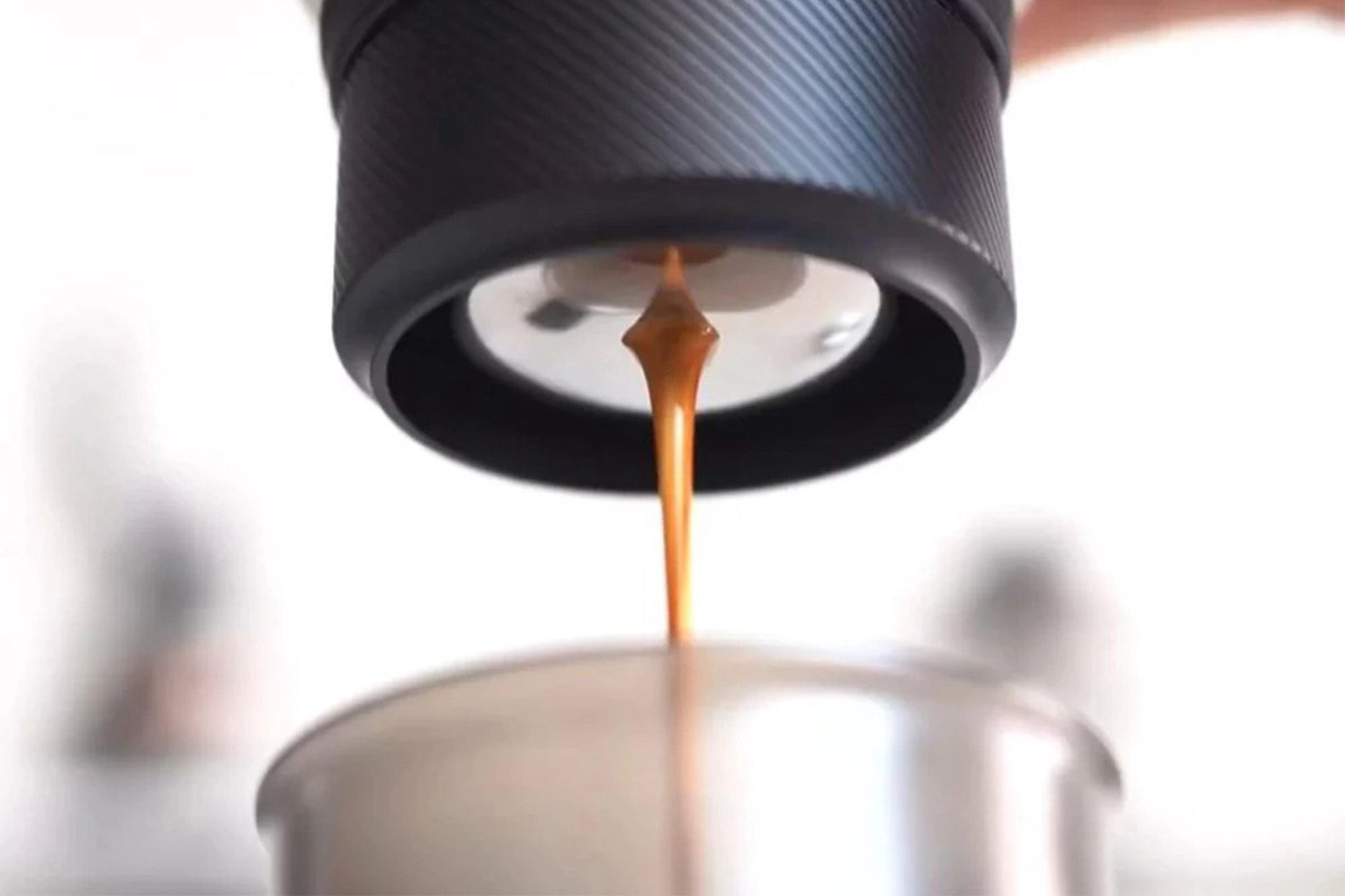 Czarny wylot kawy skrapla espresso w kolorze brązowym do metalowego kubka.