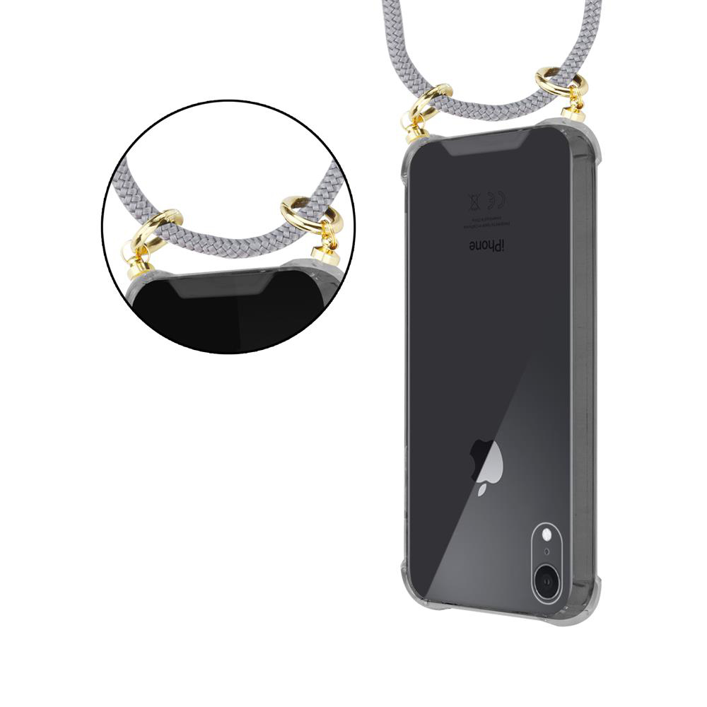 Cordino grigio con anelli dorati che sorreggono una custodia trasparente per iPhone.