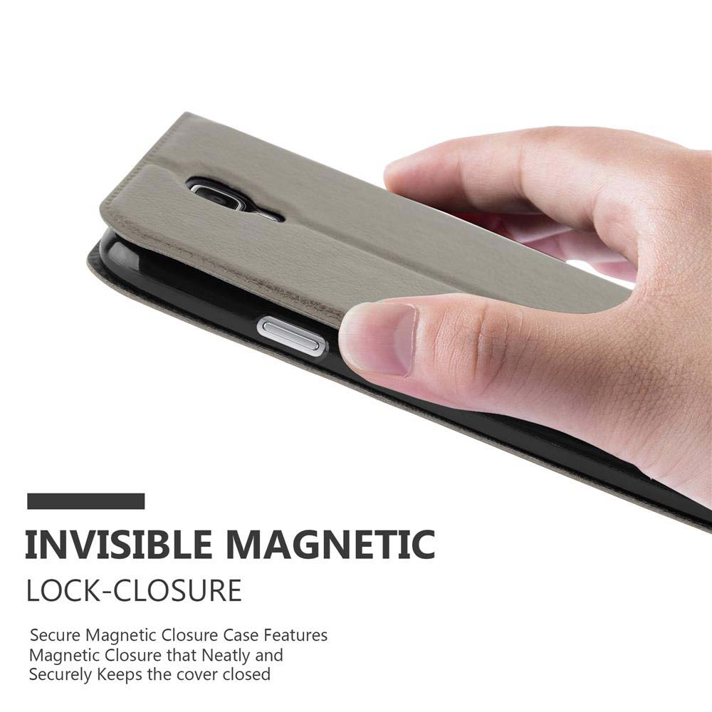 Una mano sujeta una funda de teléfono gris con cierre magnético invisible.