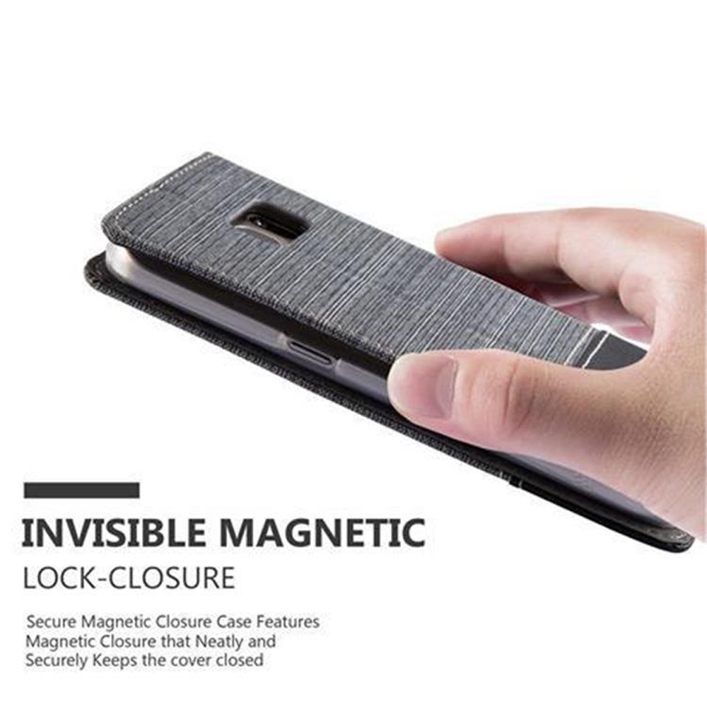 Una mano tiene una custodia grigia per telefono con chiusura magnetica.