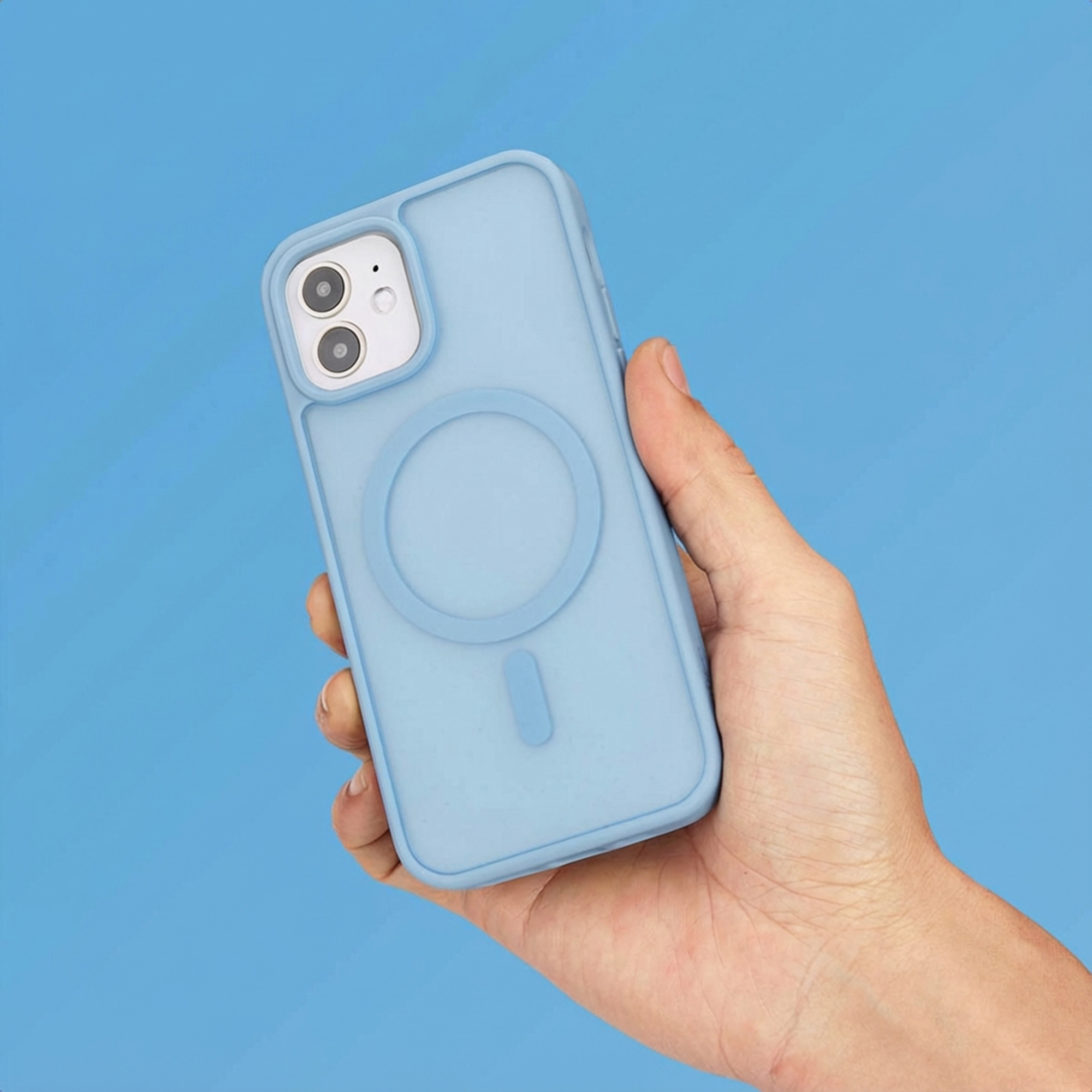 Een hand houdt een lichtblauwe telefoonhoes met cirkelvorm vast op blauwe achtergrond.