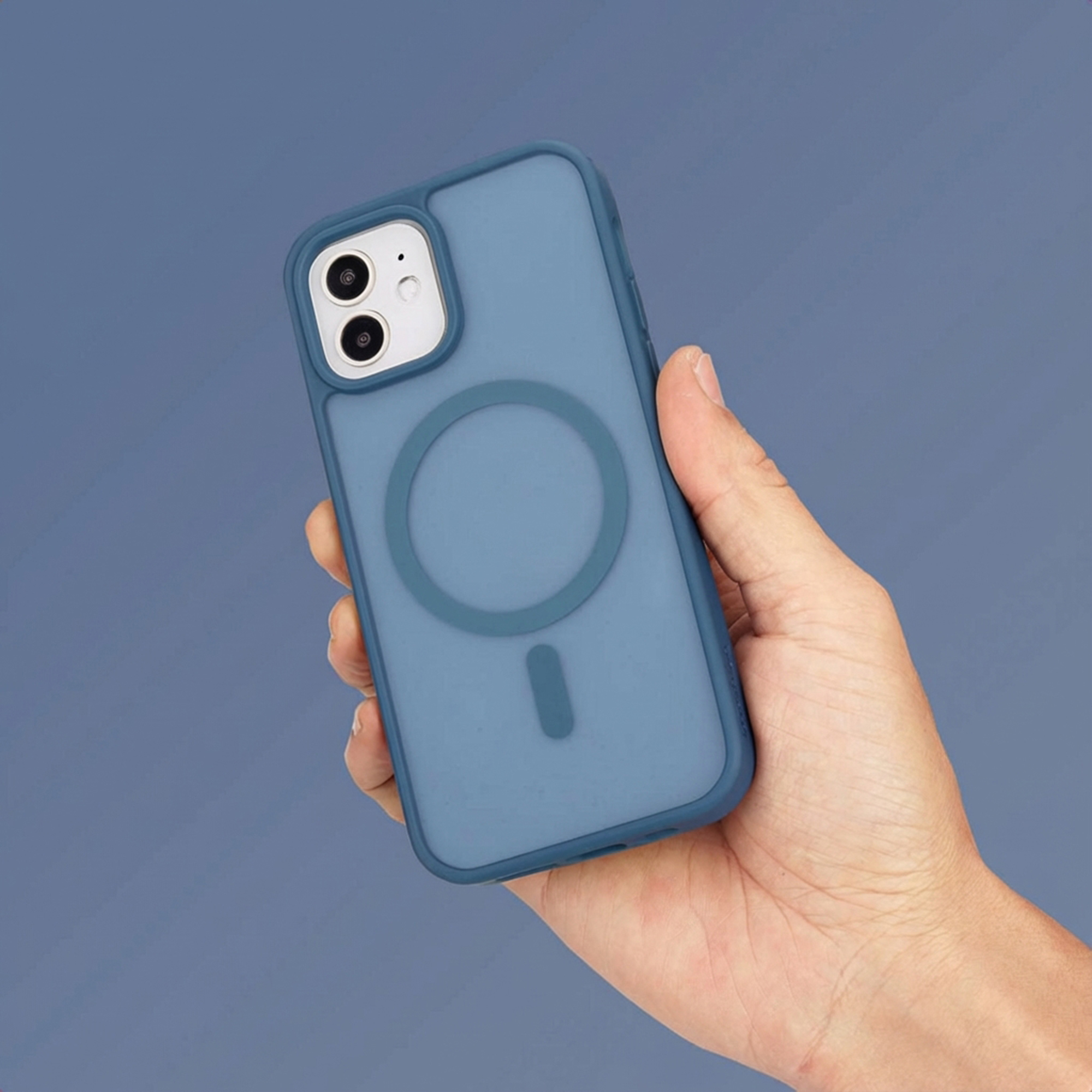Een hand houdt een blauwe telefoonhoes met magneetring vast tegen blauwe achtergrond.